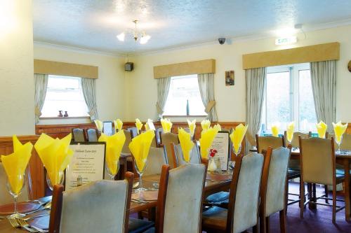 a room filled with tables and chairs with umbrellas at The Little Crown Inn in Pontypool