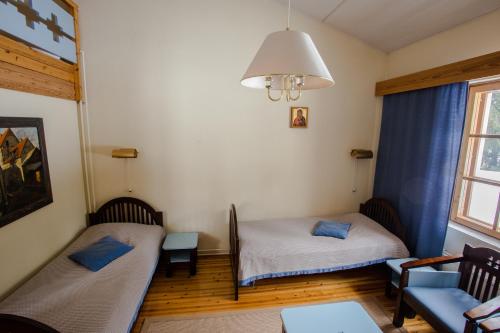 a room with two beds and a couch and a window at Valamon Luostari in Uusi-Valamo