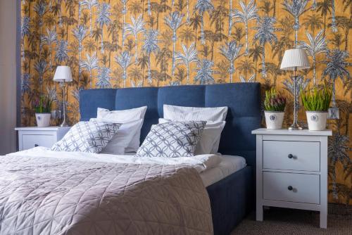 a bedroom with a blue bed with a blue and yellow wallpaper at Staycity Apartments Sukiennice 6 in Wrocław