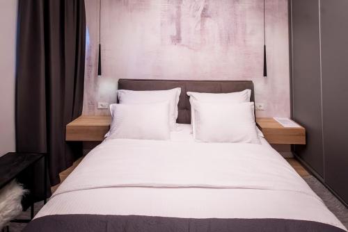 a large bed with white sheets and pillows at Emar Apartment - old town center in Zadar