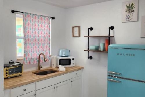 a kitchen with a sink and a blue refrigerator at Pineapple Shores Inn Unit 1 in Daytona Beach
