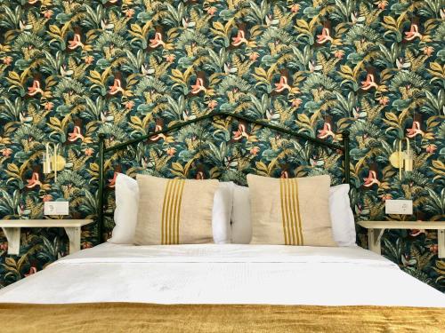 a bedroom with a large bed with a floral wallpaper at Apartamentos Makao Puerta del Olivillo in Jerez de la Frontera