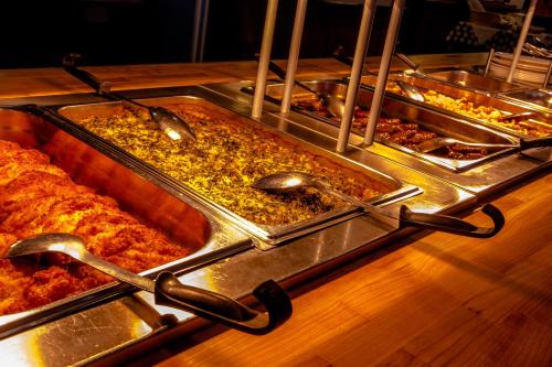 a buffet with many trays of food on a table at Valamon Luostari in Uusi-Valamo