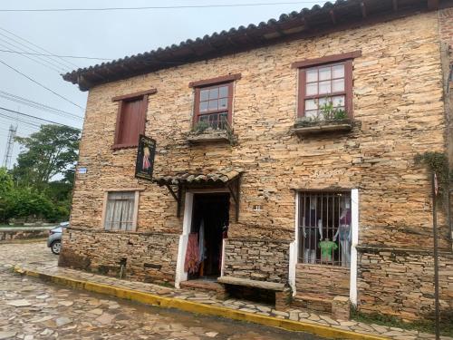 an old brick building with windows on a street at Pousada Matriz in São Thomé das Letras