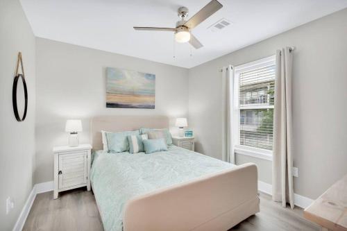 a white bedroom with a bed and a ceiling fan at Short walk or shuttle to wide open public beach! in Santa Rosa Beach