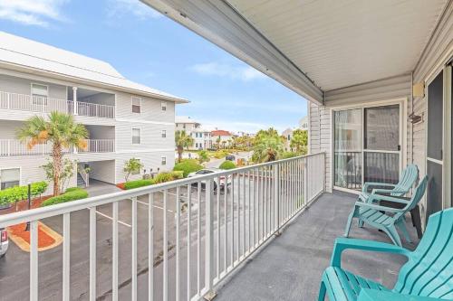 a balcony with blue chairs and a view of a street at Short walk or shuttle to wide open public beach! in Santa Rosa Beach