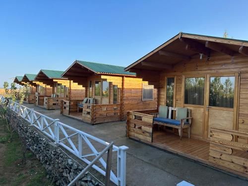 una fila de cabañas de madera en un complejo en OXUS ADVENTURE YURT CAMP en Nurota