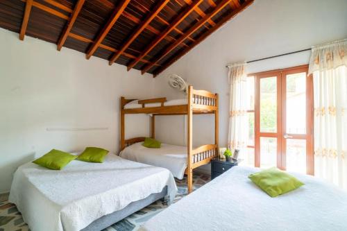 a bedroom with two bunk beds and a window at Hotel Cabañas Villa Roca, Rodadero in Santa Marta