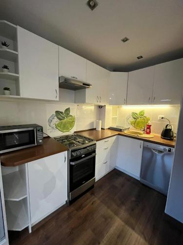 a kitchen with white cabinets and a stove top oven at Luxury apartaments Klimatyzacja in Radom