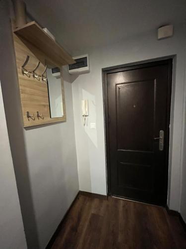 a hallway with a black door and a wooden floor at Luxury apartaments Klimatyzacja in Radom