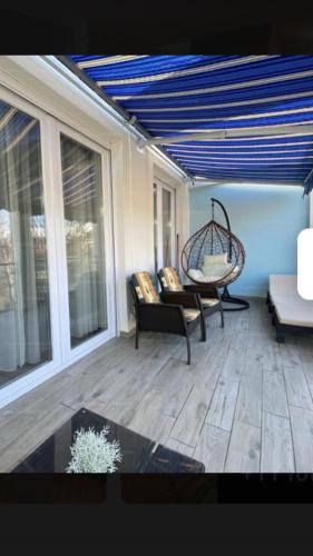 un porche cubierto con sillas y mesa en Belu Apartman en Balatonlelle