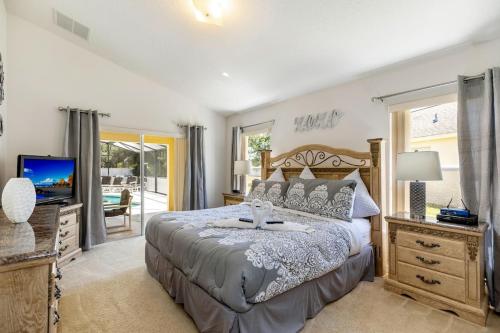 a bedroom with a large bed and a television at #196-Fantastic 6 bed villa with own private pool and spa with no rear neighbors in Orlando
