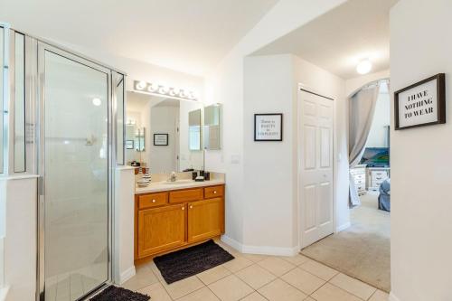 a bathroom with a shower and a sink and a mirror at #196-Fantastic 6 bed villa with own private pool and spa with no rear neighbors in Orlando