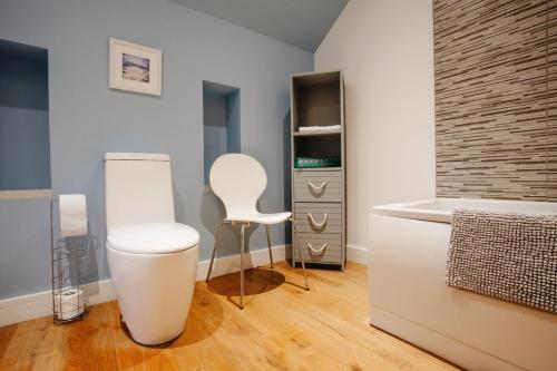 La salle de bains est pourvue d'une chaise blanche et d'un lavabo. dans l'établissement Carnanamish, à Tobermory