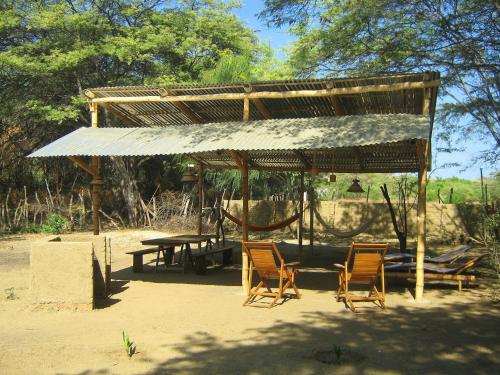 een picknickschuilplaats met stoelen en een picknicktafel bij Camping Matufa Mancora in Canoas De Punta Sal