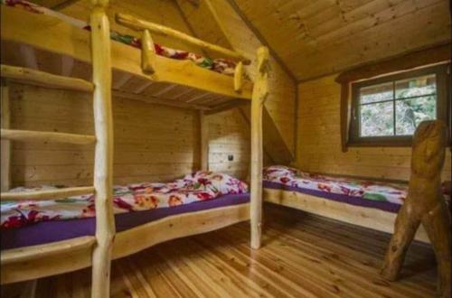 dwa łóżka piętrowe w drewnianym domku z oknem w obiekcie Wysokie Bale Kwatery Jagniatków w Jeleniej Górze