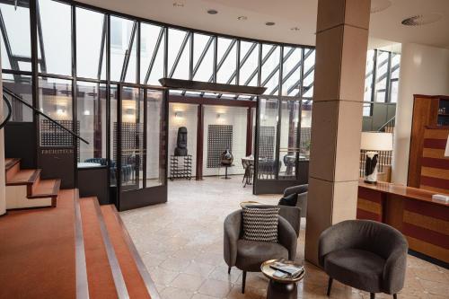 a lobby with chairs and tables and windows at Domicil Hotel Bonn in Bonn