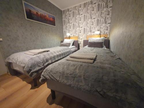 sypialnia z 2 łóżkami i malowidłem ściennym w obiekcie JDK Apartamenty Młynarska 44m2 6-osobowy w Kaliszu