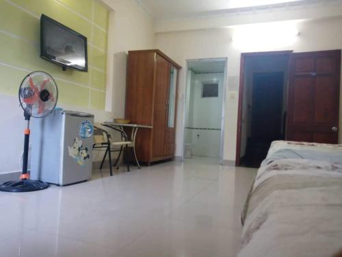 a bedroom with a room with a fan and a refrigerator at Motel Thanh Huyền in Vung Tau