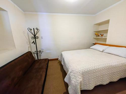 a bedroom with a bed in a white room at Centro Cusco Inti in Cusco