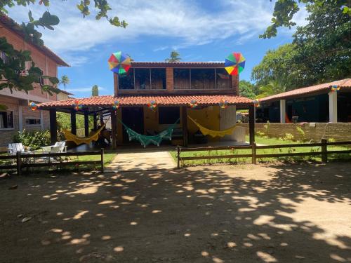 ein Haus mit einem Spielplatz mit Schaukel in der Unterkunft Vila Japaraiso-Casa Amarela Próxima ao mar in Japaratinga