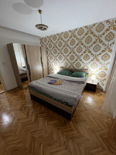 a bedroom with a bed and a wooden floor at Wel Apartment in Gevgelija