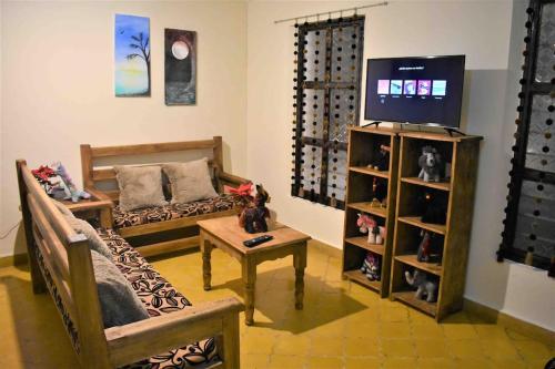 uma sala de estar com um sofá e uma televisão em La casita, ubicada en el centro em San Cristóbal de Las Casas