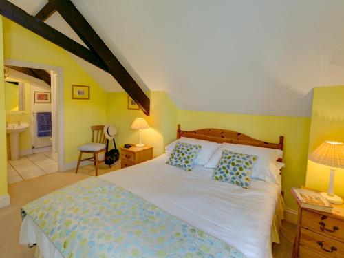 Newton FerrersにあるBrook Cottageのベッドルーム(大型ベッド1台付)、バスルームが備わります。