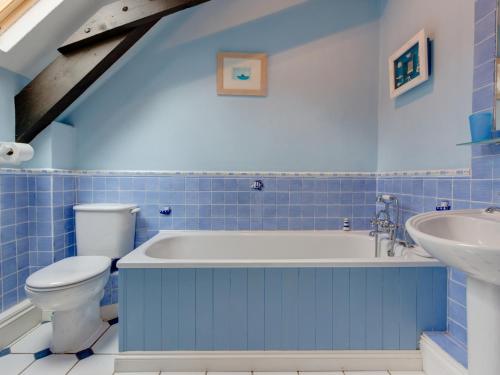 Newton FerrersにあるBrook Cottageの青いバスルーム(トイレ、シンク付)