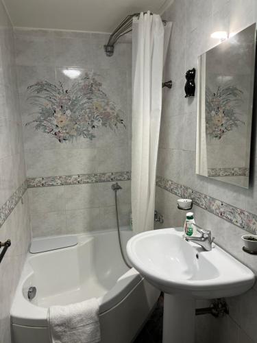 uma casa de banho com um lavatório, uma banheira branca e um lavatório. em Dimora San Ferdinando em Nápoles