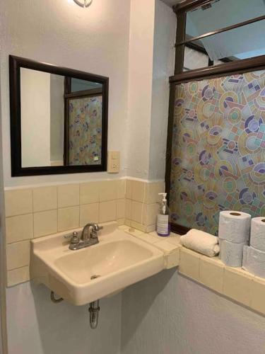 a bathroom with a sink and a mirror and towels at La casita, ubicada en el centro in San Cristóbal de Las Casas