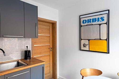 a kitchen with a sink and a wooden door at Blick Apartments - Waterfront Green Apartment in Zgorzelec