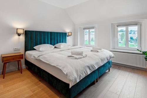 a large bed with a blue headboard in a bedroom at Blick Apartments - Waterfront Green Apartment in Zgorzelec