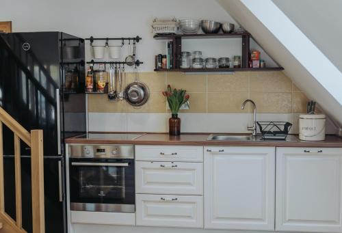 a kitchen with white cabinets and a sink at Apartments Možinetova hiša in Šentjošt nad Horjulom