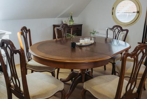 a dining room table and chairs with a table and a mirror at Apartments Možinetova hiša in Šentjošt nad Horjulom