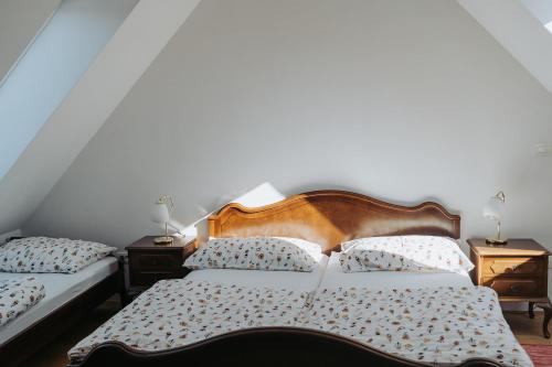 a bedroom with two beds and two night stands at Apartments Možinetova hiša in Šentjošt nad Horjulom