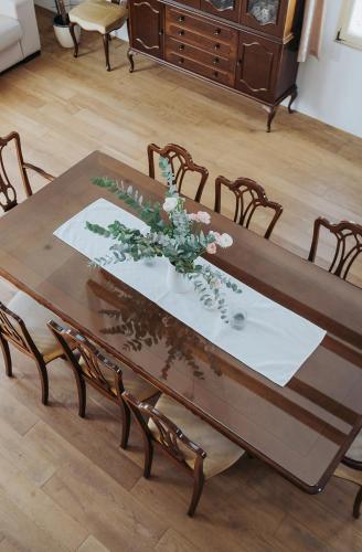 a wooden dining table with chairs and a table cloth at Apartments Možinetova hiša in Šentjošt nad Horjulom