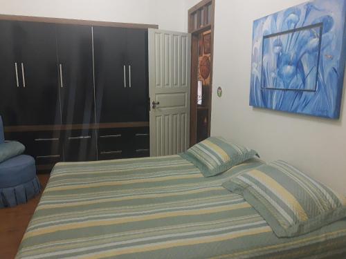 ein Schlafzimmer mit einem Bett und einem Wandgemälde in der Unterkunft CHEZ ALE in Bragança Paulista