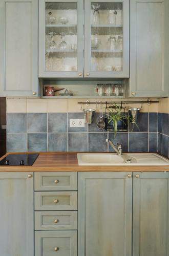 a kitchen with white cabinets and a sink at Apartments Možinetova hiša in Šentjošt nad Horjulom