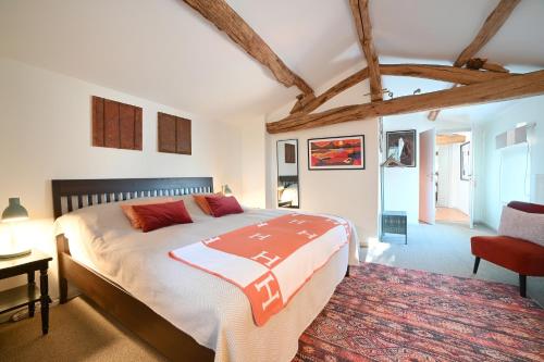- une chambre avec un grand lit et une chaise rouge dans l'établissement Mas des Gourmands, à La Mothe-Saint-Héray