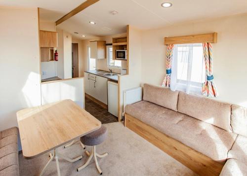 a living room with a couch and a table at Eastern Beach Caravan Park in Caister-on-Sea