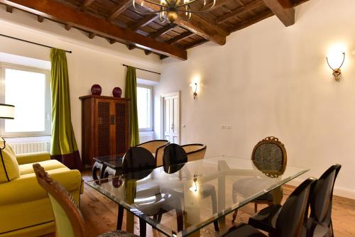 Residenza Clodio Spanish Steps في روما: غرفة معيشة مع طاولة وكراسي زجاجية