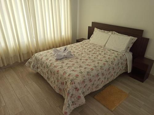 a bedroom with a bed with a bow on it at Hermosa y espléndida casa en Oxapampa in Oxapampa