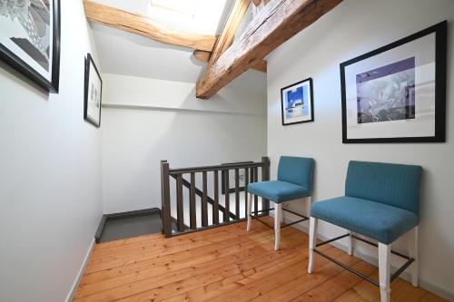 two blue chairs in a room with a staircase at Mas des Gourmands in La Mothe-Saint-Héray