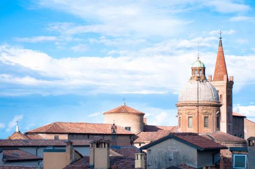a building with a tower and a steeple and roofs at Hotel Touring in Bologna