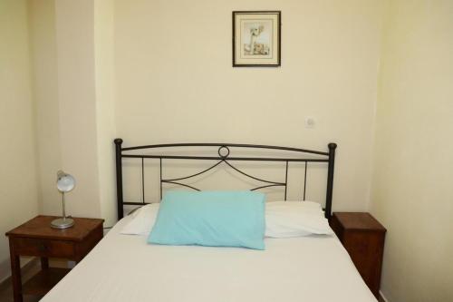 Una cama con una almohada azul encima. en VANGELIS-Triopetra, en Triopetra