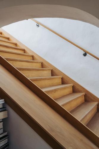 a set of wooden stairs in a room with a piano at Apartments Možinetova hiša in Šentjošt nad Horjulom