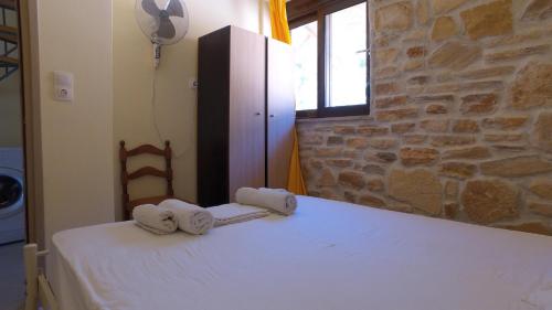 a bedroom with a white bed with towels on it at DESPOINA-Triopetra in Triopetra