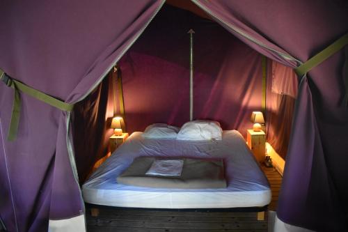 a bedroom with a bed in a tent at Camping Les Pins de Sel in Saint-Augustin