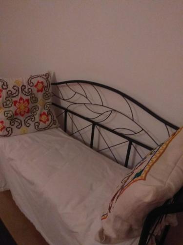 a bed with a metal headboard and pillows on it at B&B Ma Maison in Govone